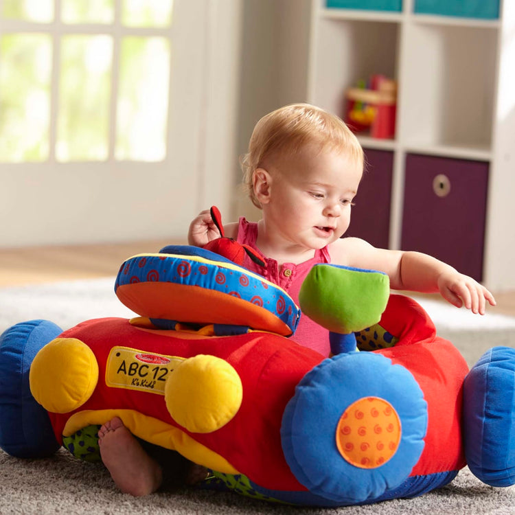 A kid playing with the Melissa & Doug Beep-Beep and Play Activity Center Baby Toy