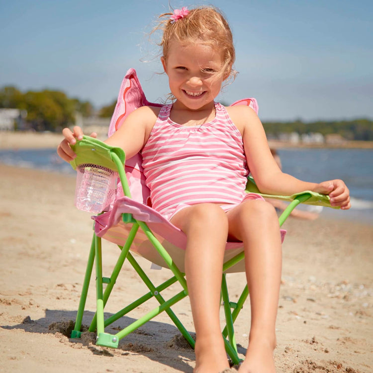 A kid playing with the Melissa & Doug Sunny Patch Bella Butterfly Outdoor Folding Lawn and Camping Chair