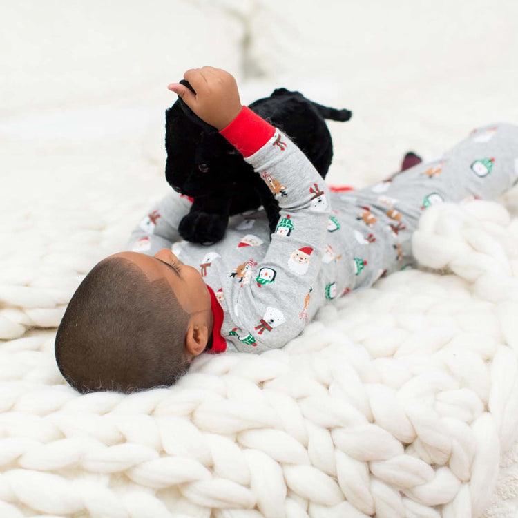 A kid playing with the Melissa & Doug Benson Black Lab - Stuffed Animal Puppy Dog