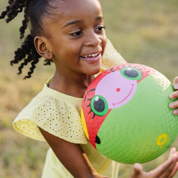 A kid playing with the Melissa & Doug Sunny Patch Bollie Ladybug Classic Rubber Kickball