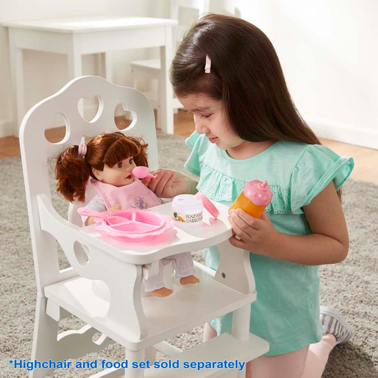 A kid playing with the Melissa & Doug Mine to Love Brianna 12-Inch Soft Body Baby Doll With Hair and Outfit