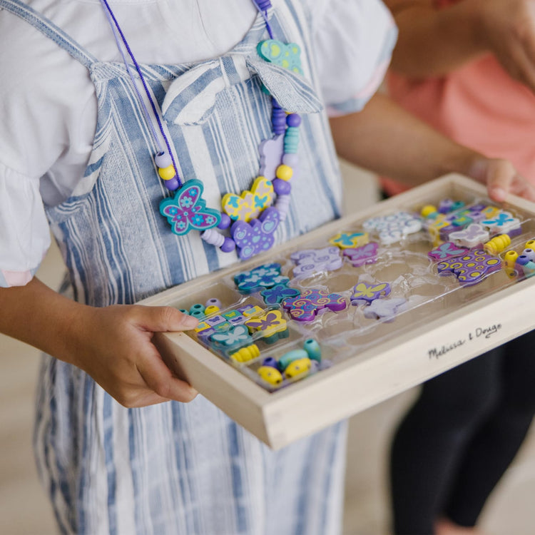 The front of the box for the Melissa & Doug Created by Me! Butterfly Beads Wooden Bead Kit, 150+ Beads for Jewelry-Making