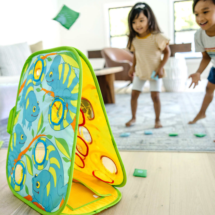 A kid playing with the Melissa & Doug Sunny Patch Camo Chameleon Bean Bag Toss Action Game