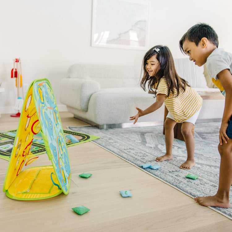 A kid playing with the Melissa & Doug Sunny Patch Camo Chameleon Bean Bag Toss Action Game