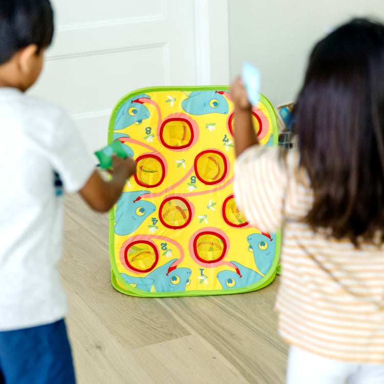 A kid playing with the Melissa & Doug Sunny Patch Camo Chameleon Bean Bag Toss Action Game