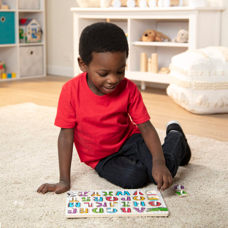 A kid playing with the Melissa & Doug Classic Wooden Peg Puzzles (Set of 3) - Numbers, Alphabet, and Colors