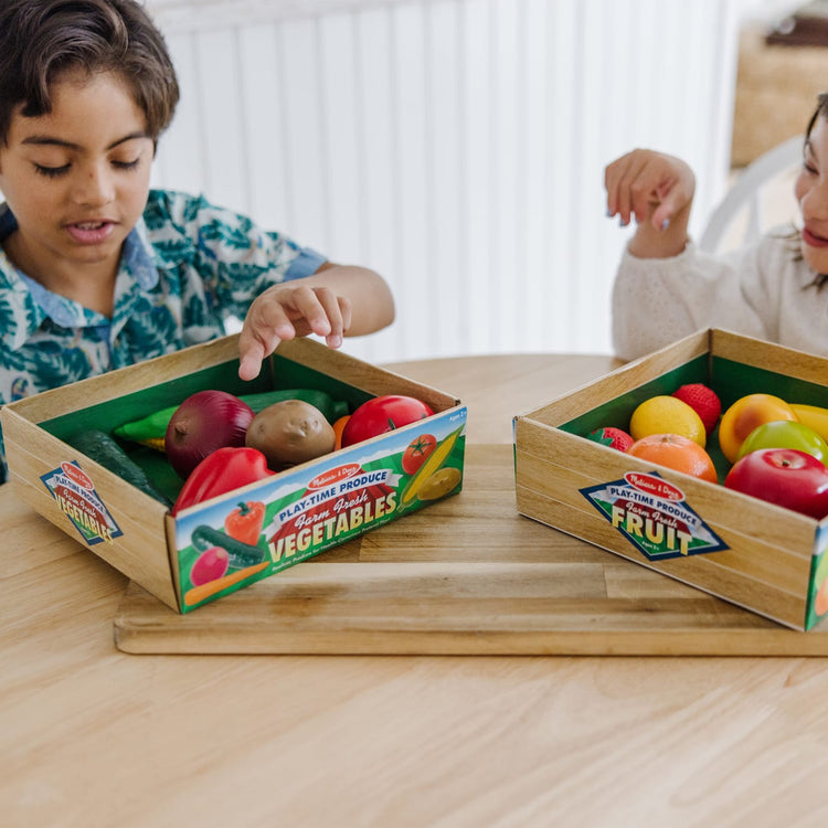 A kid playing with the Melissa & Doug Play-Time Produce Fruit (9 pcs) and Vegetables (7 pcs) Realistic Play Food