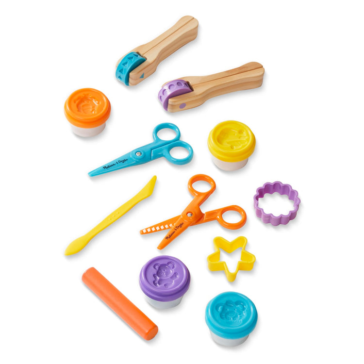 The loose pieces of the Melissa & Doug Created by Me! Cut, Sculpt, and Roll Modeling Dough Kit With 8 Tools and 4 Colors of Modeling Dough