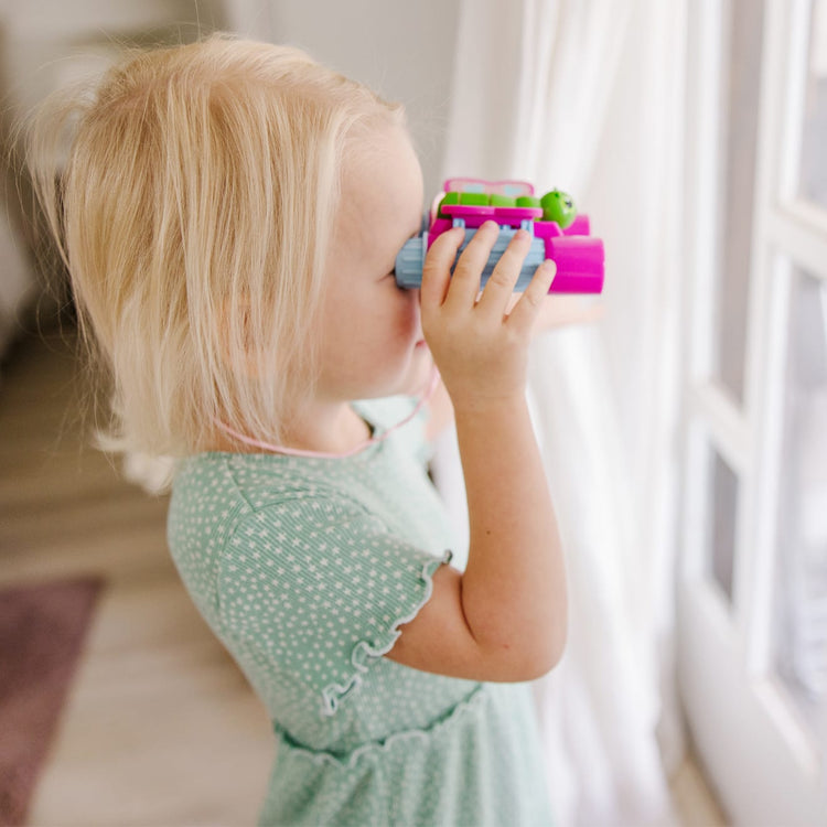 A kid playing with the Melissa & Doug Sunny Patch Cutie Pie Butterfly Binoculars - Pretend Play Toy