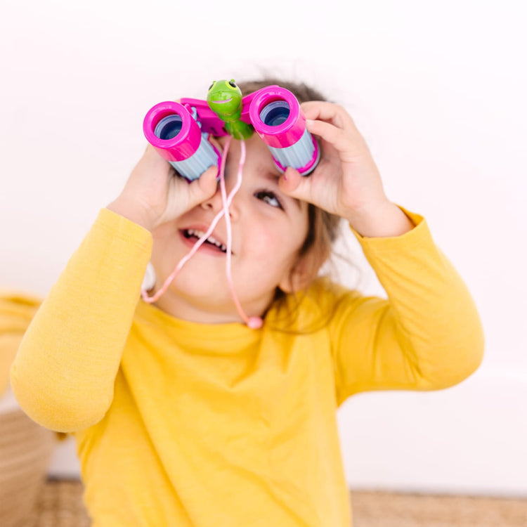 A kid playing with the Melissa & Doug Sunny Patch Cutie Pie Butterfly Binoculars - Pretend Play Toy