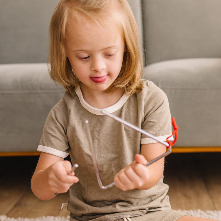 A kid playing with the Melissa & Doug Deluxe Band Set With Wooden Musical Instruments and Storage Case