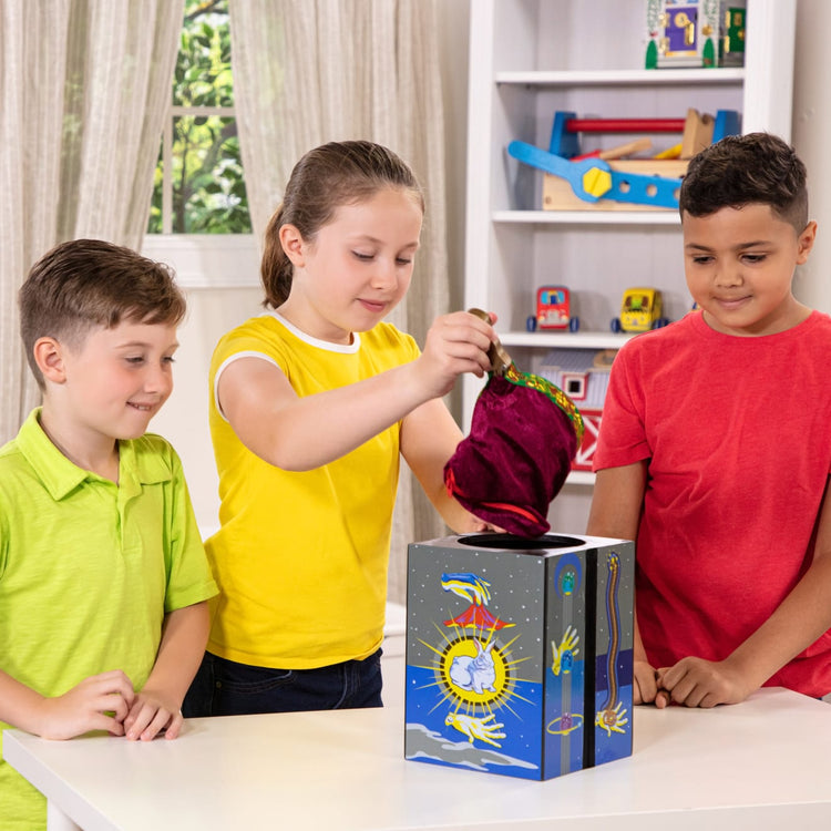 A kid playing with the Melissa & Doug Deluxe Solid-Wood Magic Set With 10 Classic Tricks