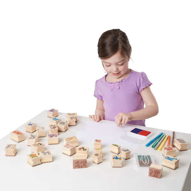 A child on white background with the Melissa & Doug Deluxe Wooden Stamp Set: Animals - 30 Stamps, 6 Markers, 2 Stamp Pads