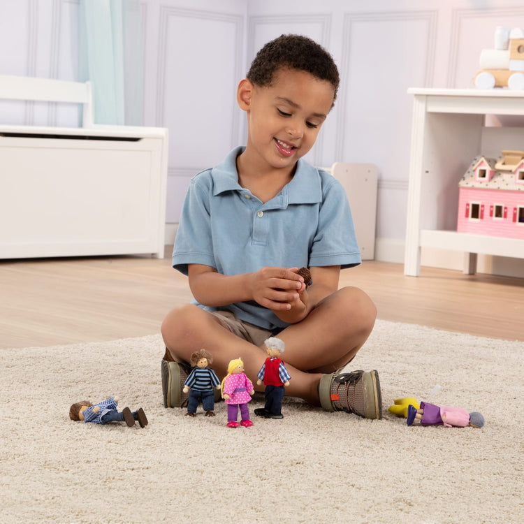 A kid playing with the Melissa & Doug 7-Piece Poseable Wooden Doll Family for Dollhouse (2-4 inches each)