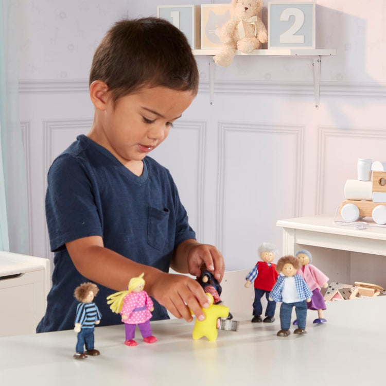 A kid playing with the Melissa & Doug 7-Piece Poseable Wooden Doll Family for Dollhouse (2-4 inches each)