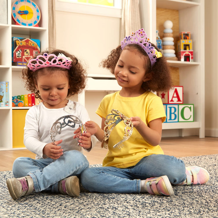 A kid playing with the Melissa & Doug Dress-Up Tiaras for Costume Role Play (4 pcs)