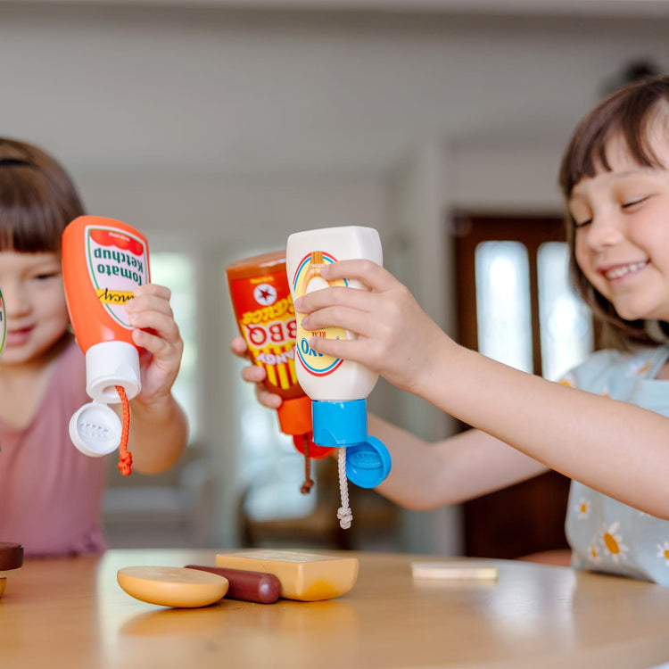 A kid playing with the Melissa & Doug 5-Piece Favorite Condiments Play Food Set