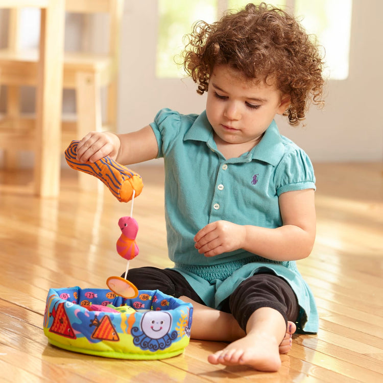 A kid playing with the Melissa & Doug K's Kids Fish and Count Learning Game With 8 Numbered Fish to Catch and Release