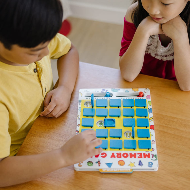 A kid playing with the Melissa & Doug Flip to Win Travel Memory Game - Wooden Game Board, 7 Double-Sided Cards