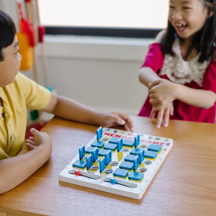 A kid playing with the Melissa & Doug Flip to Win Travel Memory Game - Wooden Game Board, 7 Double-Sided Cards