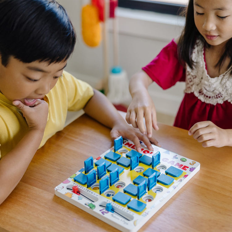 A kid playing with the Melissa & Doug Flip to Win Travel Memory Game - Wooden Game Board, 7 Double-Sided Cards