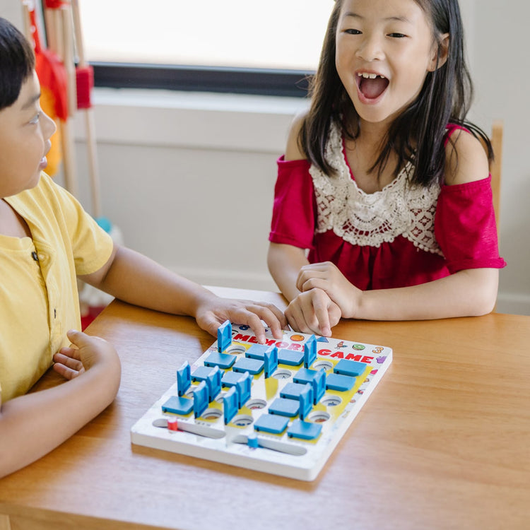 A kid playing with the Melissa & Doug Flip to Win Travel Memory Game - Wooden Game Board, 7 Double-Sided Cards