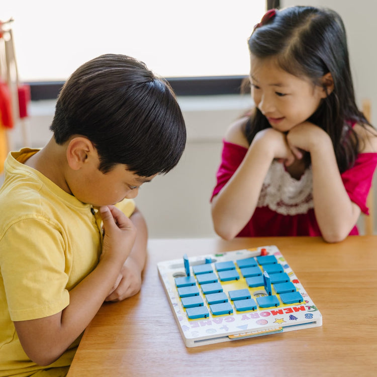 A kid playing with the Melissa & Doug Flip to Win Travel Memory Game - Wooden Game Board, 7 Double-Sided Cards