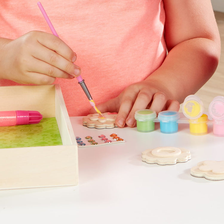 The front of the box for the Melissa & Doug Created by Me! Flower Wooden Magnets Craft Kit (4 Designs, 4 Paints, Stickers, Glitter Glue)