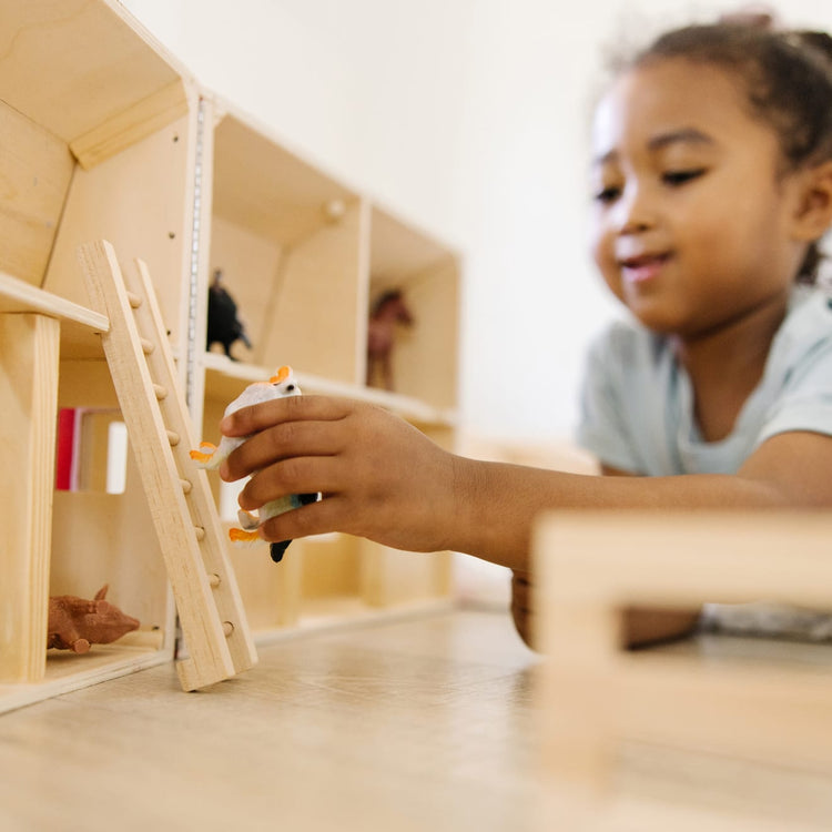 A kid playing with the Melissa & Doug Fold and Go Wooden Barn With 7 Animal Play Figures