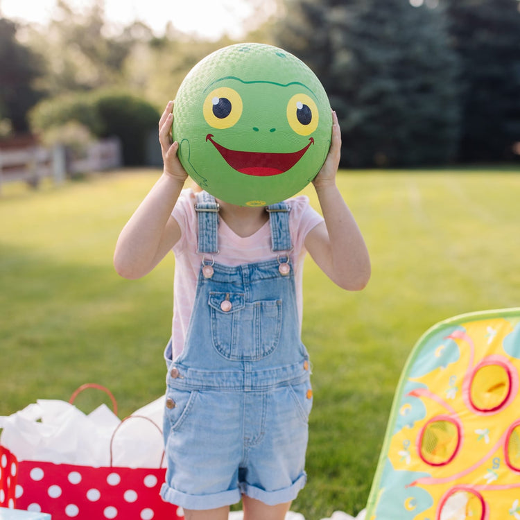 A kid playing with the Melissa & Doug Sunny Patch Froggy Classic Rubber Kickball