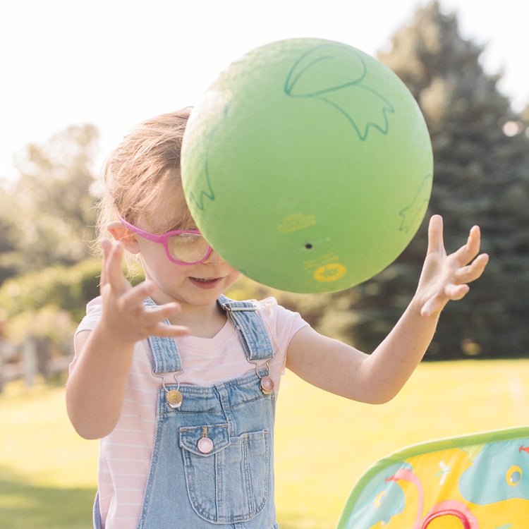 A kid playing with the Melissa & Doug Sunny Patch Froggy Classic Rubber Kickball