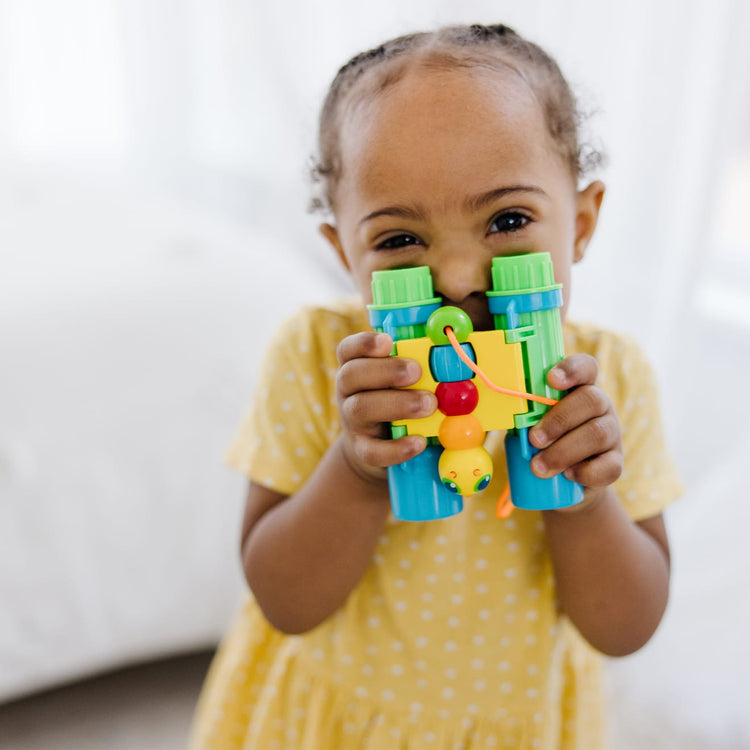 A kid playing with the Melissa & Doug Sunny Patch Giddy Buggy Binoculars - Pretend Play Toy