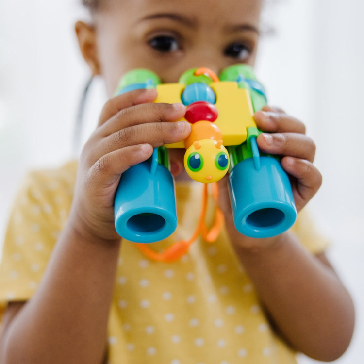 A kid playing with the Melissa & Doug Sunny Patch Giddy Buggy Binoculars - Pretend Play Toy