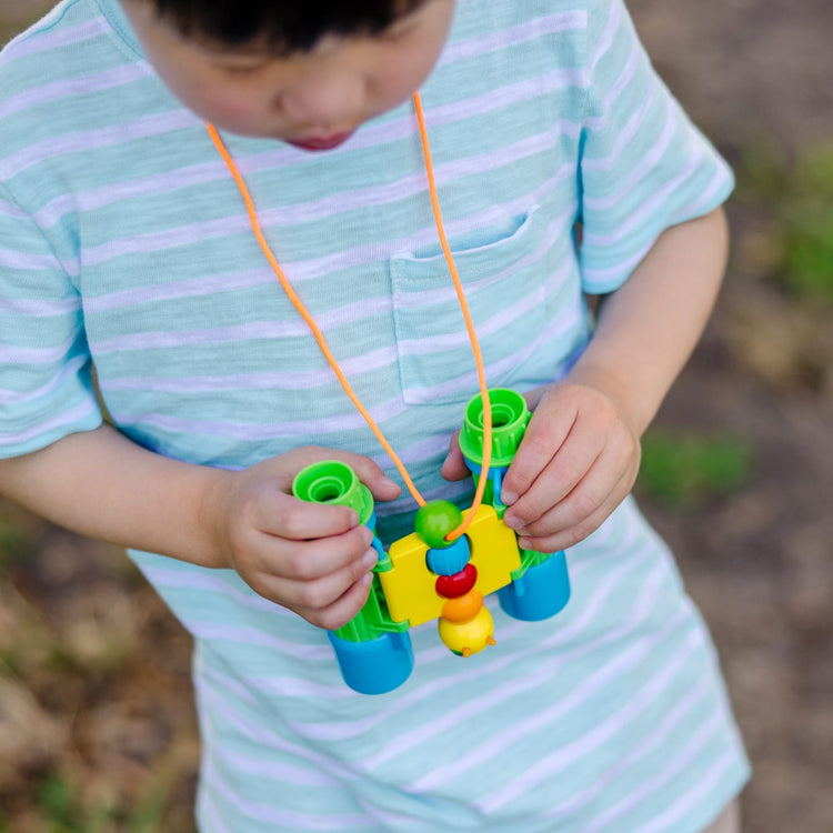 A kid playing with the Melissa & Doug Sunny Patch Giddy Buggy Binoculars - Pretend Play Toy