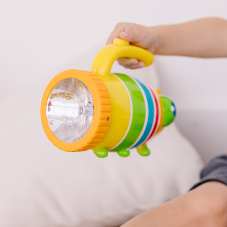 A kid playing with the Melissa & Doug Sunny Patch Giddy Buggy Flashlight With Easy-Grip Handle