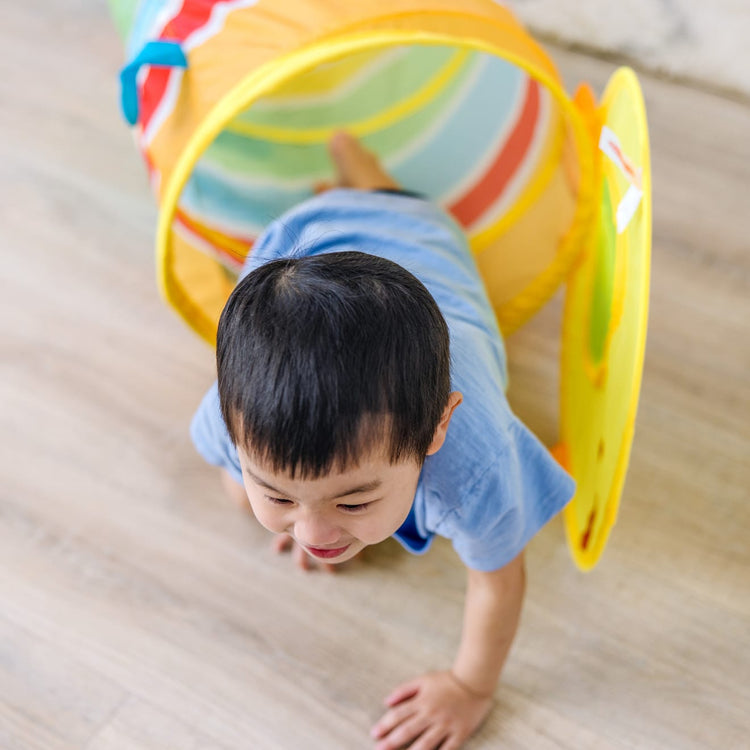 A kid playing with the Melissa & Doug Sunny Patch Giddy Buggy Crawl-Through Tunnel (almost 5 feet long)