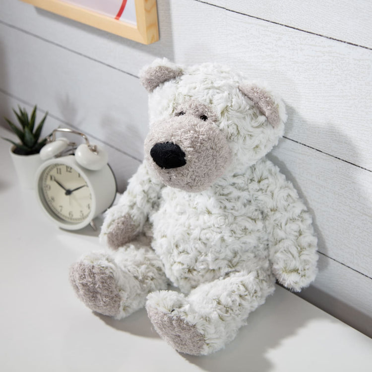 A kid playing with the Melissa & Doug Greyson Bear Stuffed Animal