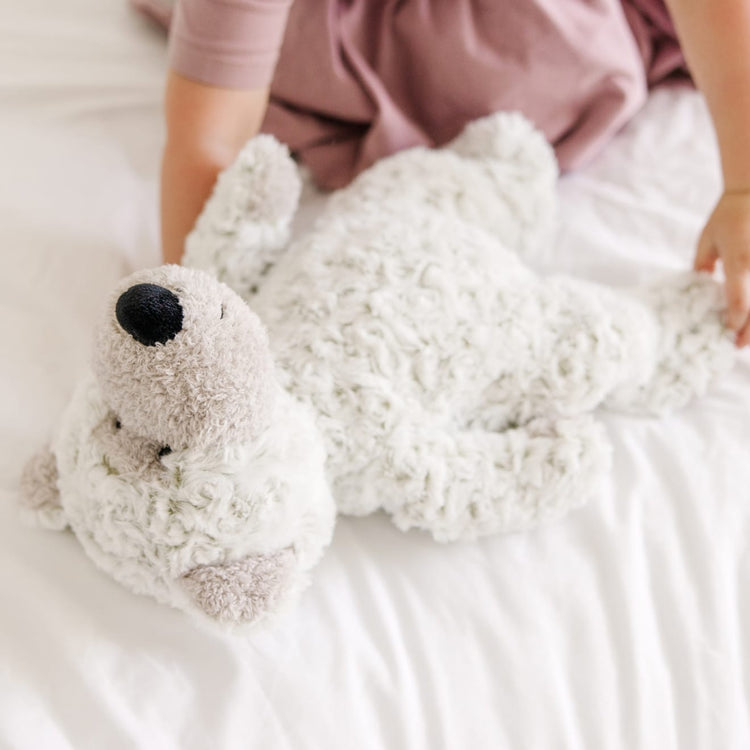 A kid playing with the Melissa & Doug Greyson Bear Stuffed Animal