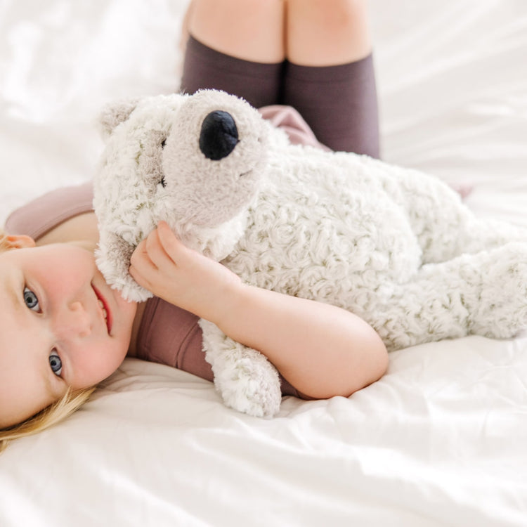 A kid playing with the Melissa & Doug Greyson Bear Stuffed Animal