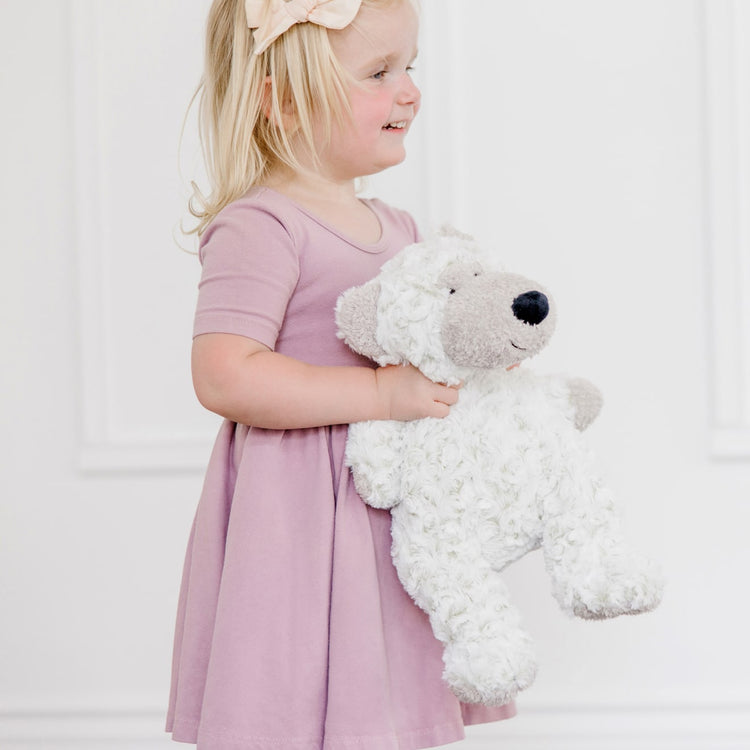 A kid playing with the Melissa & Doug Greyson Bear Stuffed Animal