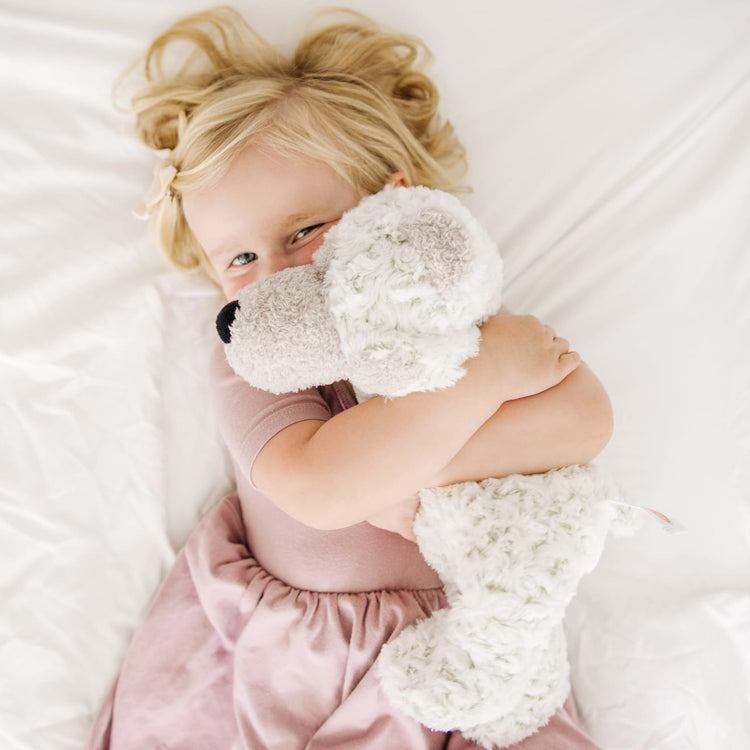 A kid playing with the Melissa & Doug Greyson Bear Stuffed Animal