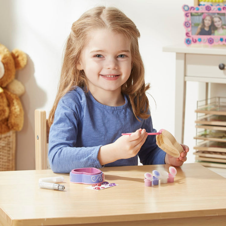 A kid playing with the Melissa & Doug Created by Me! Heart Box Wooden Craft Kit