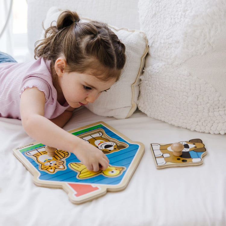 A kid playing with the Melissa & Doug Pets Jumbo Knob Wooden Puzzle