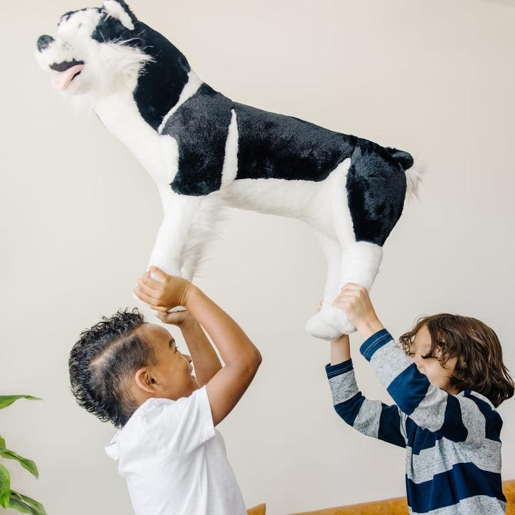 A kid playing with the Melissa & Doug Giant Siberian Husky - Lifelike Stuffed Animal Dog (over 2 feet tall)