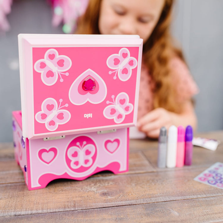 A kid playing with the Melissa & Doug Created by Me! Jewelry Box Wooden Craft Kit