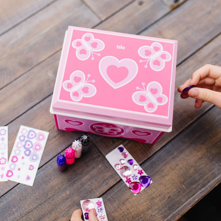 A kid playing with the Melissa & Doug Created by Me! Jewelry Box Wooden Craft Kit