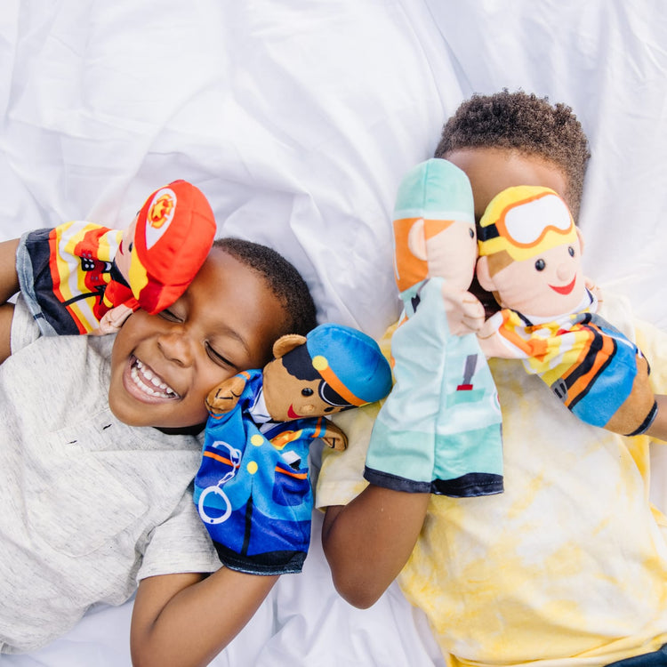 A kid playing with the Melissa & Doug Jolly Helpers Hand Puppets (Set of 4) - Construction Worker, Doctor, Police Officer, and Firefighter