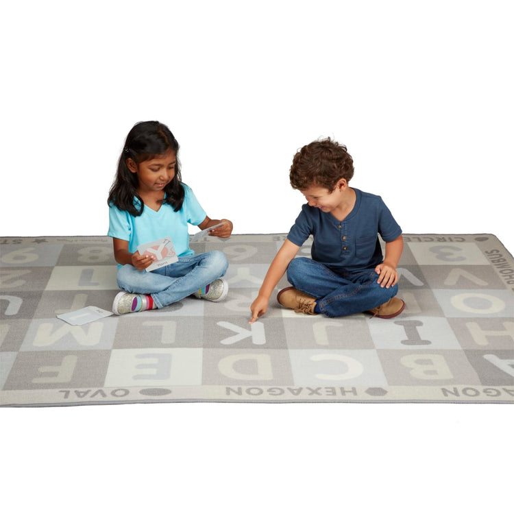 A child on white background with the Melissa & Doug Jumbo ABC-123 Rug Neutral (58 x 79 inches – 36 Game Cards)