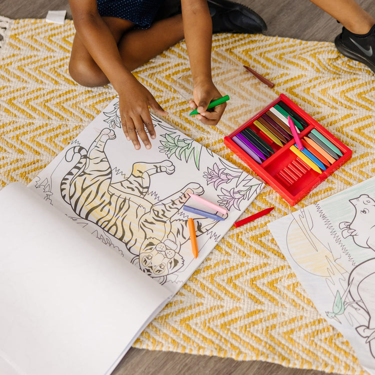 A kid playing with the Melissa & Doug Jumbo Coloring Pad (11 x 14 inches) - Animals, 50 Pictures