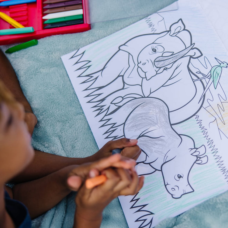 A kid playing with the Melissa & Doug Jumbo Coloring Pad (11 x 14 inches) - Animals, 50 Pictures